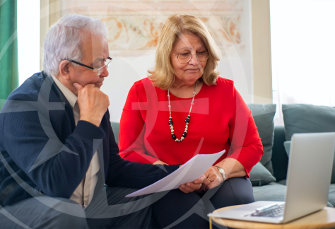 Seniors reviewing financial paperwork with a wealth advisor.